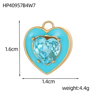 Detail van een gouden hartvormige hanger met blauwe zirkoon, 1,6cm bij 1,4cm