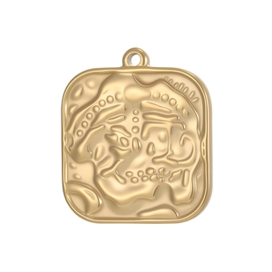 Detailed view of square gold pendant with embossed abstract vintage face pattern