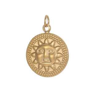 Macro detail of golden sun face pendant with textured relief and round dot border