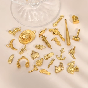 Vue détaillée de pendentifs dorés en acier inoxydable avec animaux et divers objets