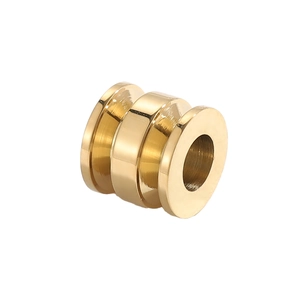 Detailed macro view of golden stainless steel cylindrical jewelry bead with center hole