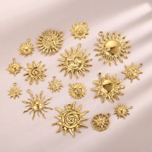 Collection of 16 gold sun smile face pendants for DIY jewelry making on pink background
