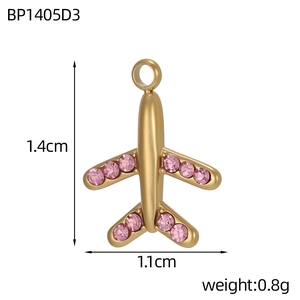 Macro detail of 1.4cm gold airplane charm with pink rhinestones for DIY jewelry