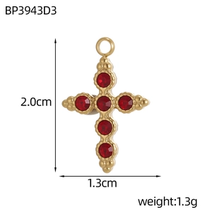 Macro shot of 18k gold plated cross pendant with red crystals and dimension markings