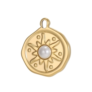 Macro detail of a gold coin pendant with white faux pearl and sunburst relief texture