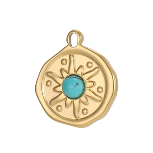 Detail of vintage gold coin pendant featuring a turquoise stone and sunburst pattern
