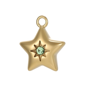 Macro detail of gold-plated star pendant with a sparkling green center crystal