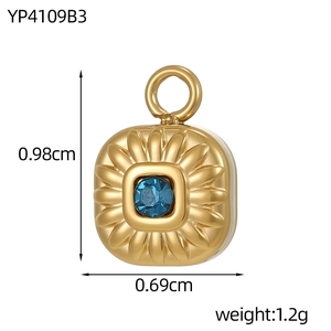 Macro detail of gold square pendant with blue zircon center and floral relief pattern