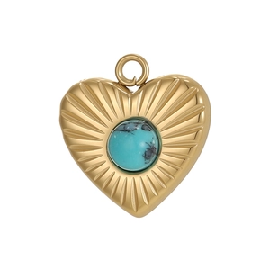 Macro detail of a golden heart pendant featuring radial texture and a blue turquoise stone
