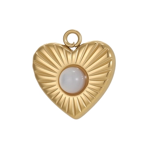 Detail of 18K gold heart pendant with sunburst texture and centered white cabochon gem