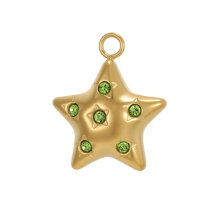 Détail d'un pendentif étoile dorée orné de cinq cristaux verts sur un fond blanc pur