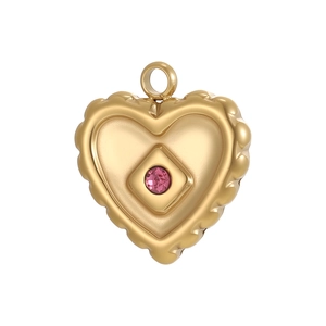 Detail eines Vintage-Herzanhängers aus Gold mit rosa Edelstein und Wellenrand