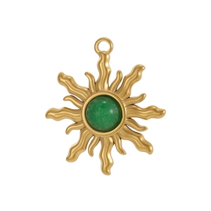 Detailed macro view of a gold sunflower pendant with a green gemstone inlay and bail