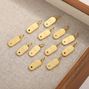 12er-Set goldene Geburtsstein-Anhänger mit Gravur und gebürstetem Finish auf Holztablett
