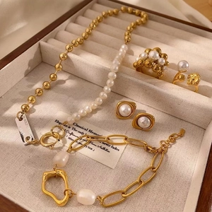 Elegantes Set aus goldenen Schleifen-Ohrringen und Perlenschmuck in einer Box