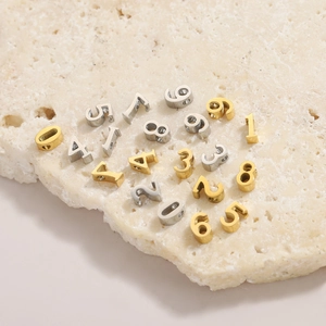 Close-up of gold and silver numbered stainless steel beads with holes for DIY jewelry