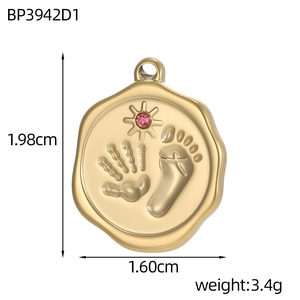 Detail of round gold pendant with baby handprints, pink gemstone, and dimensions 1.98cm