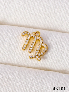Detailed macro view of a gold-plated Virgo zodiac pendant with micro-paved sparkling crystals