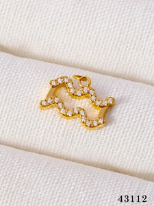 Detailed macro of gold-plated Aquarius zodiac pendant with sparkling CZ stones inlay