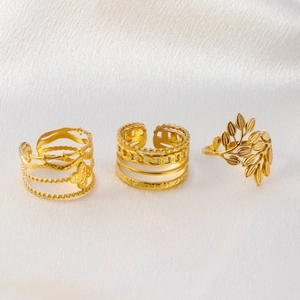 Three-piece gold plated minimalist rings including clover, chain link, and leaf designs