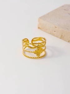 Detail of layered gold ring with hammered clover charm and textured wave bands