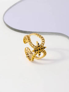 Macro detail of gold-plated double-layer chain ring with black stone star element