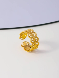 Detail of gold hollow star pattern ring with an adjustable open band and heart accents