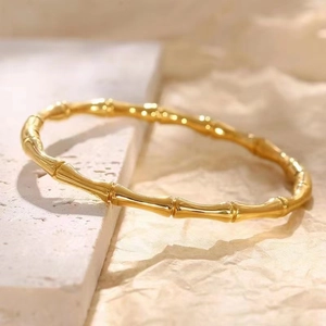 Vue détaillée du bracelet en acier inoxydable doré style bambou sur fond minéral