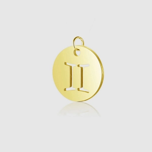 Macro shot of gold stainless steel circular pendant with Gemini Roman numeral cutout