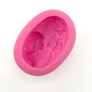 Macro detail of oval silicone mold featuring an intricate girl and flower carving