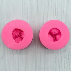 Detail of two round pink silicone molds with 3D floral textures for DIY crafts