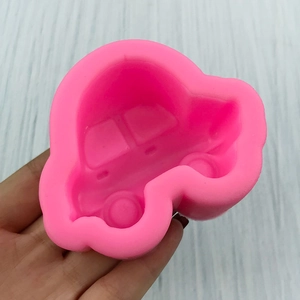 Pink cartoon car silicone mold for chocolate and fondant baking on gray wood background