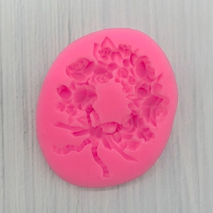 Macro detail of pink silicone mold with intricate floral rose and leaf patterns