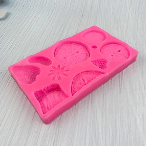 Pink silicone mold with strawberry and citrus fruit shapes for fondant and cake decorating