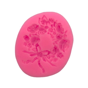 Pink silicone mold with detailed rose bouquet and ribbon bow for fondant cake decoration