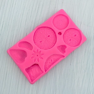 Macro shot of pink silicone mold with strawberry and citrus fruit shapes for fondant