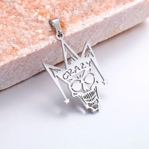 Detalle de colgante de calavera en acero inoxidable con corona y grabado CRAZY estilo rock