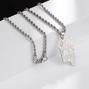 Dettaglio della collana gotica argentata con croce e cuore sacro su base geometrica