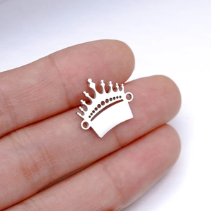 Macro shot of mirror-polished stainless steel crown pendant with dual hanging loops