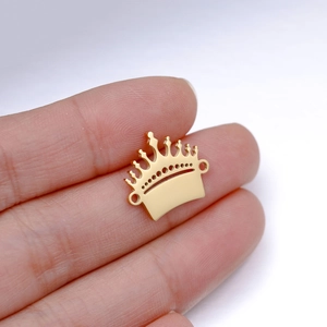 Detailed macro view of golden stainless steel crown charm with dual attachment holes