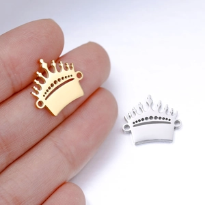 Macro view of gold and silver crown charms being held to show small scale and size