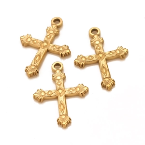 Macro view of gold cross pendants with vintage embossed floral details and polished finish