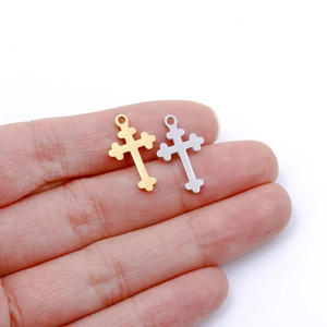 Dettaglio di piccoli ciondoli a croce in acciaio inox oro e argento per gioielli fai da te