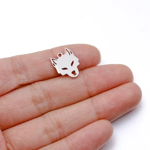 Pendentif tête de loup en acier poli montrant des détails évidés et une texture métallique brillante