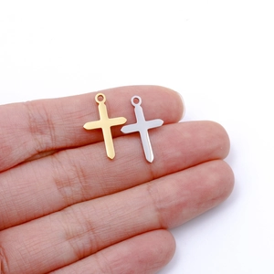 Dettaglio macro di ciondoli a croce in acciaio inox oro e argento per le dimensioni