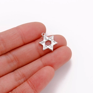 Detailed view of silver hexagram star pendant held in hand to show scale and metal finish