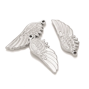 Detailed macro view of three silver stainless steel angel wing pendants for DIY jewelry