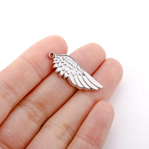 Detail showing the intricate feather texture and compact size of the wing pendant