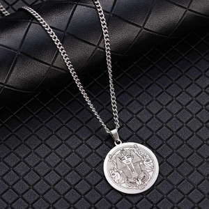 Detailed close-up of a silver Egyptian Pharaoh pendant on a black textured background