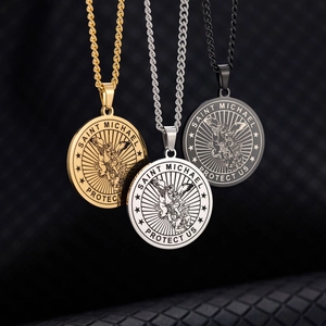 Close-up of Saint Michael Archangel pendants in gold silver and black steel